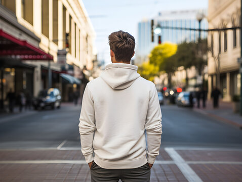 photo and focus of the back of a man wearing a white hoodie in the city. Generative AI