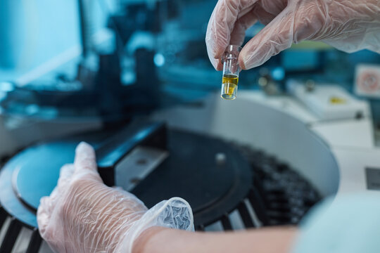 Researcher, doctor, scientist or laboratory assistant working with a glass flask on a centrifuge in a modern laboratory or hospital - Powered by Adobe