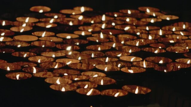 Tourist floating water candle lamps in pond during Diwali celebration.