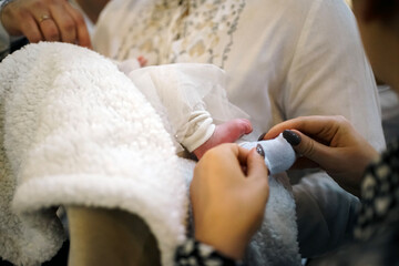The legs of a newborn during church baptism.