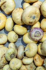 Fresh turnips on the counter in a supermarket. Healthy foods and vegetarianism. Close-up. TOP view. Vertical.