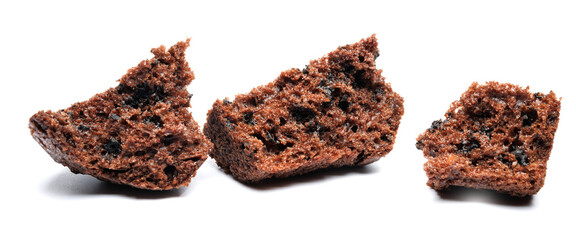 Chocolate muffin broken into pieces isolated on a white background. Chocolate chip muffin.