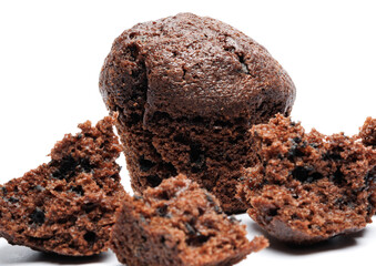 Whole and broken into pieces chocolate muffin isolated on a white background. Chocolate chip muffin.