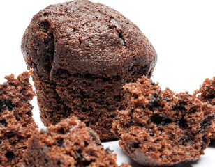 Whole and broken into pieces chocolate muffin isolated on a white background. Chocolate chip muffin.
