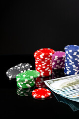 Poker chips and dollar bills on black background studio shot