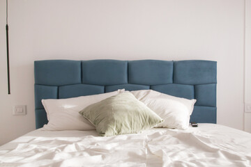 Fototapeta na wymiar Cozy and elegant bedroom. Blue king size bed with white cotton bedding.
