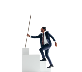 Ambitious businessman working his way to the top of a staircase on a transparent background