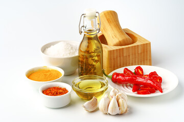 Bowls with spices and cooking ingredients on white background