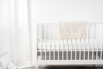 White wooden baby crib in nursery room - obrazy, fototapety, plakaty