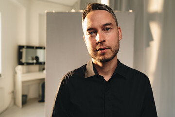 Portrait of a man in black shirt posing in photostudio