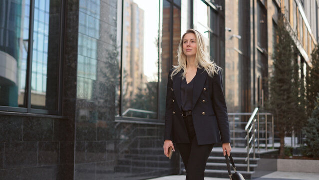 Pretty 30s business woman take walk. Sexy lady boss city stroll. Attractive 40 years old businesswoman. Successful top manager step. Confident serious girl gait. Person wear black job suit close up.