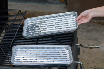 Tacki z aluminium kladzione na ruszt grilla © Paweł Kacperek