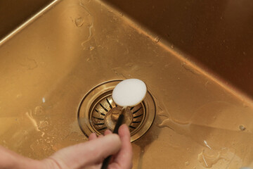 Cleaning kitchen sink with bakIng soda to keep sinks draining well and prevent clogs. Safe, effective, cheap, natural solution for clogged drains. - obrazy, fototapety, plakaty