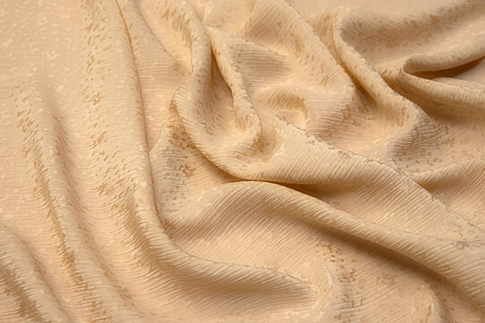 Abstract background texture of natural beige or brown colour fabric. Fabric texture of natural cotton or linen, silk or satin, wool or jersey textile material. Luxurious canvas background..