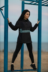 Fitness girl on outdoor sports ground in an anorak in windy weather