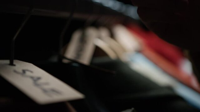 Hand Checking validity of Clothes for Sale 