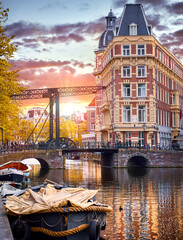 Amsterdam, Netherlands. Panoramic view of autumn Dutch city. Famous channel Amstel river. Evening cityscape. Colorful sunset scene famous travel destination in Europe. Romantic traveling place - obrazy, fototapety, plakaty