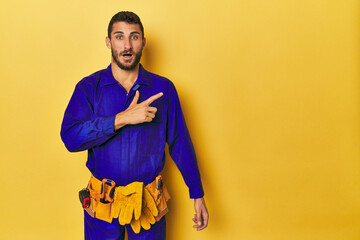 Young Hispanic man in a blue jumpsuit Young Hispanic man in a blue jumpsuitpointing to the side