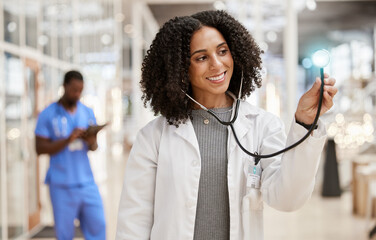 Woman, doctor and stethoscope with thinking, hospital and smile for check, overlay and light in corridor. African medic, tools and happy for healthcare job, service and listening with glow in clinic