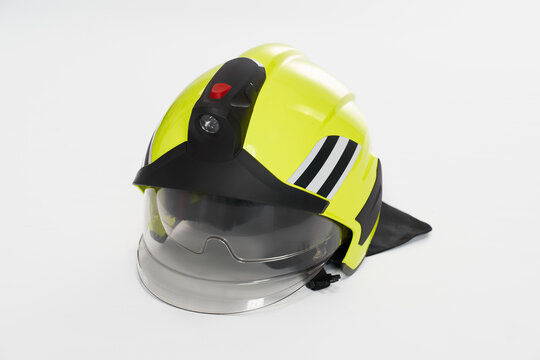 Yellow fireman's helmet lying on white studio background. Close up view of protective firefighter's helmet, hat with plastic shield, with copy space. Concept of emergency, protection, equipment.