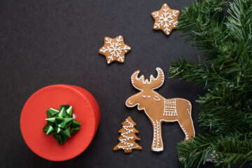 Gingerbread cookies in the shape of moose and snowflakes on a dark background. Christmas and New Year's