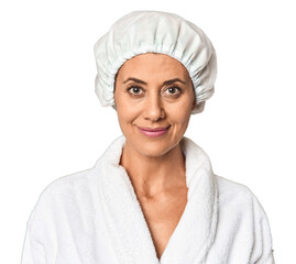 Middle-aged woman in bathrobe with shower cap in studio