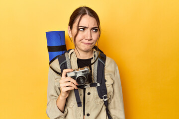 Photographer with gear ready to explore confused, feels doubtful and unsure.