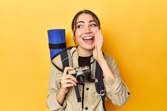 Photographer with gear ready to explore shouting and holding palm near opened mouth.
