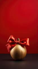 gold christmas ball with red ribbon