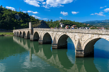 Naklejka premium Visegrad, Bosnia and Herzegovina - August 13, 2023: Famous bridge on the Drina in Visegrad, Bosnia and Herzegovina. Mehmed Pasa Sokolovic Bridge on Drina River