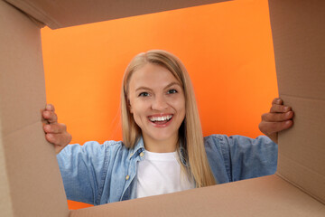 An attractive blonde looks into a cardboard box