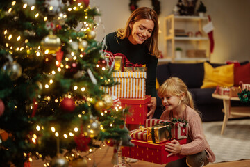 Obraz na płótnie Canvas Putting Christmas gifts under the Christmas tree