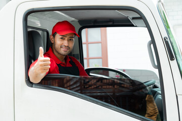 Happy Asian or Indian worker, delivery driver man, thumbs up to camera working in professional moving house services company sitting in shipping truck, men at work shipping small business entrepreneur