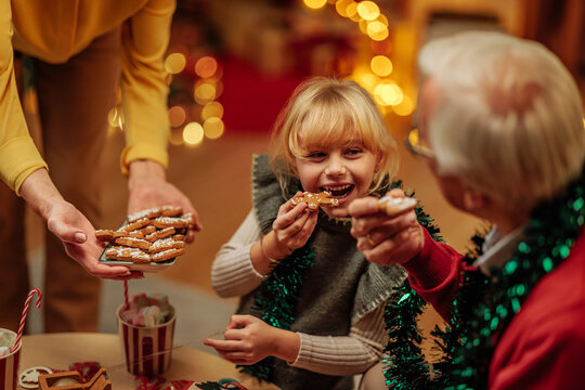 Girl eating Christmas cookies with her grandparents