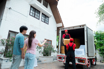 Happy couple moving house by using professional moving house services company deliver to new house...