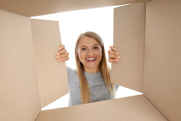 PNG,The girl looks into a cardboard box, isolated on white background