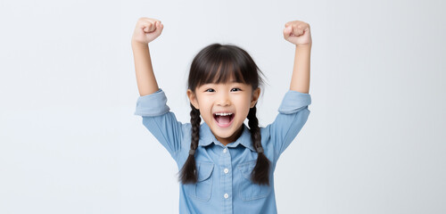A 6-8 year old Asian girl, looking good and cheerful, stood with her arms raised in great joy, In the clear background, Generative AI