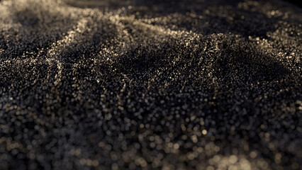 Black glitter with gold flecks. Golden loosened sand on ground.