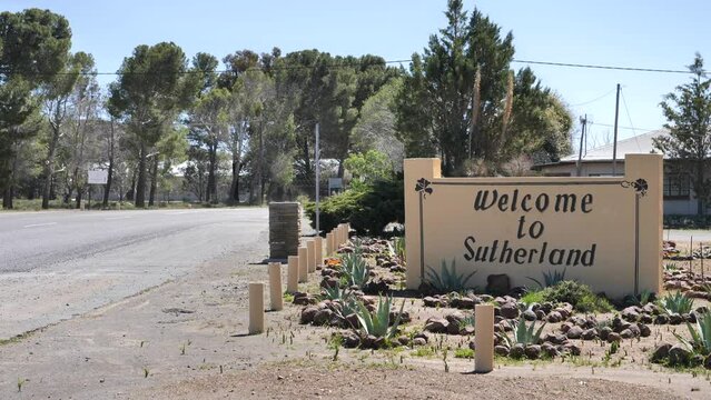 Sutherland, South Africa - September 27, 2023: Welcome to Sutherland sign painted on wall surrounded by rock and succulent garden at entrance to town