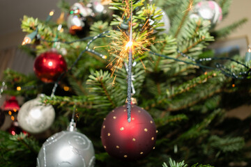 Bengal fire is sparkling on a christmas tree in Liechtenstein