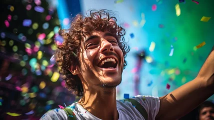 Foto op Aluminium Brazilian Carnival. Youthful man getting a charge out of the carnival party blowing confetti © Elshad