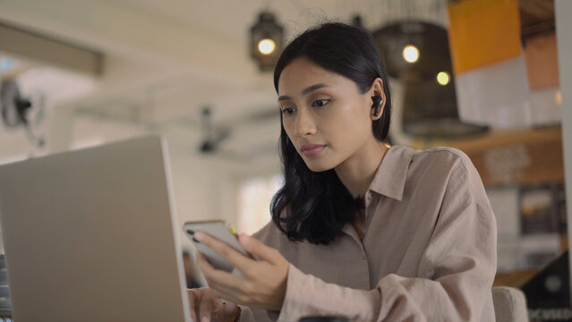 Asian freelancer cell cafe. Busy person use computer macbook coworking place. Boss woman look screen monitor. People study iphon network. Female user start up laptop desk. Coworker girl job home space