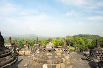 (Selective focus) Stunning view of a Buddha Statue in the foreground and some bell shaped stupas in...