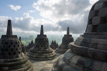 (Selective focus) Stunning view of the Borobudur bell shaped stupas during a beautiful sunrise....