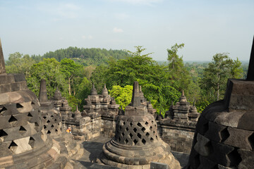 (Selective focus) Stunning view of the Borobudur bell shaped stupas during a beautiful sunrise. Borobudur is a Mahayana Buddhist temple in Magelang Regency in Central Java, Indonesia.