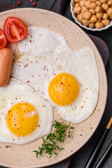 Fried chicken eggs, sausages, cherry tomatoes, chickpeas, spices, salt and herbs
