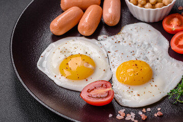 Fried chicken eggs, sausages, cherry tomatoes, chickpeas, spices, salt and herbs