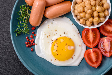 Fried chicken eggs, sausages, cherry tomatoes, chickpeas, spices, salt and herbs
