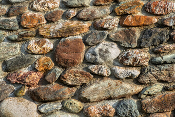 close-up view of a stonewall with different shaped and coloured stones