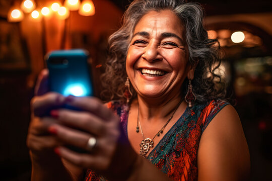 Generative AI image of smiling elderly female in gray curly hair looking at screen of smartphone while standing and taking selfie during night against blurred illuminated lights